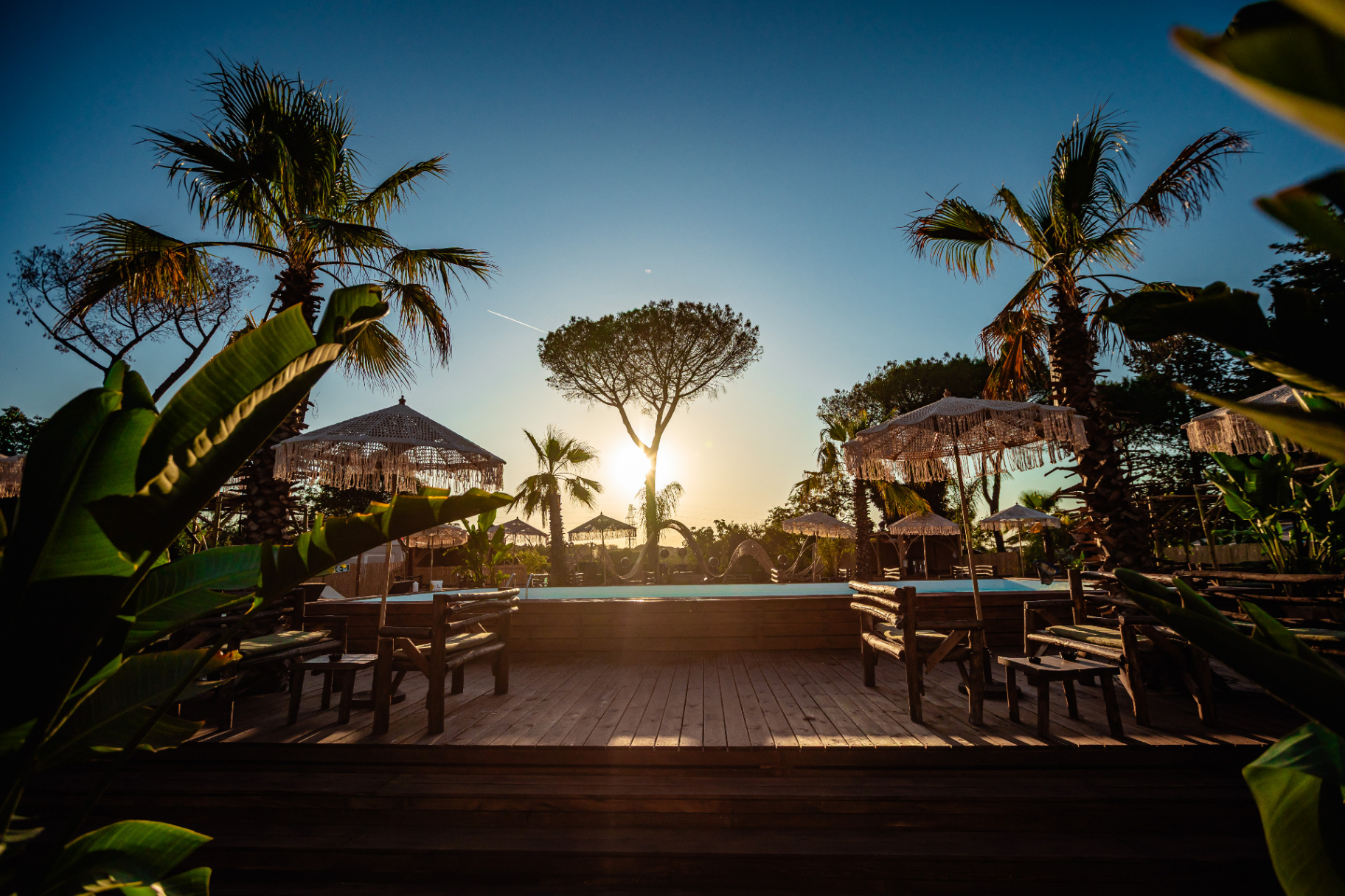 Piscina di Kalaya al tramonto tra palme e pini